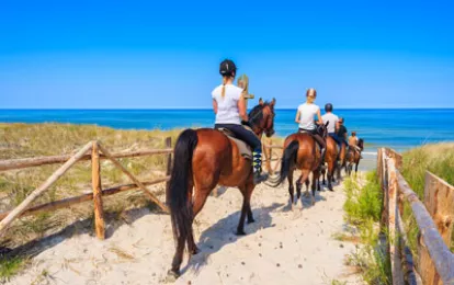 Eine Gruppe junger Frauen reitet zum Sandstrand bei ihrem Kururlaub in Lubiatowo an der Ostsee in Polen.