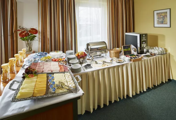 Frühstücksbuffet im Spa Hotel Děvín mit Aufschnitt, Käse, Müsli, frischem Obst und Kaffeemaschine
