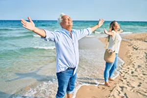 Hispanisches Paar praktiziert Atemtherapie am Strand