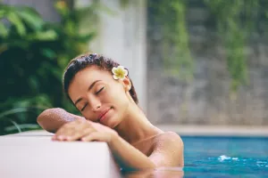 Sinnliche junge Frau entspannt im Außenpool des Spas während einer Badekur