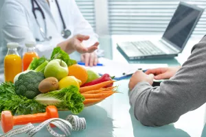 Ernährungsberater berät den Patienten über gesunde Ernährung mit Gemüse und Obst bei einer Kuraufenthalt.