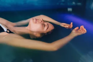 Frau schwimmt in Salzbad-Tank