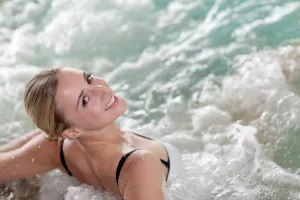 Frau entspannt in einem Meerwasserpool während der Thalassotherapie mit Algen und anderen marinen Elementen.